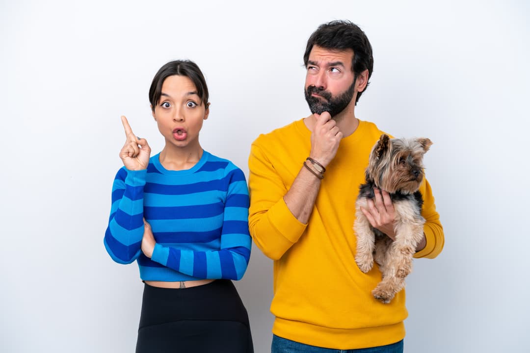young hispanic woman holding dog isolated white background standing thinking idea